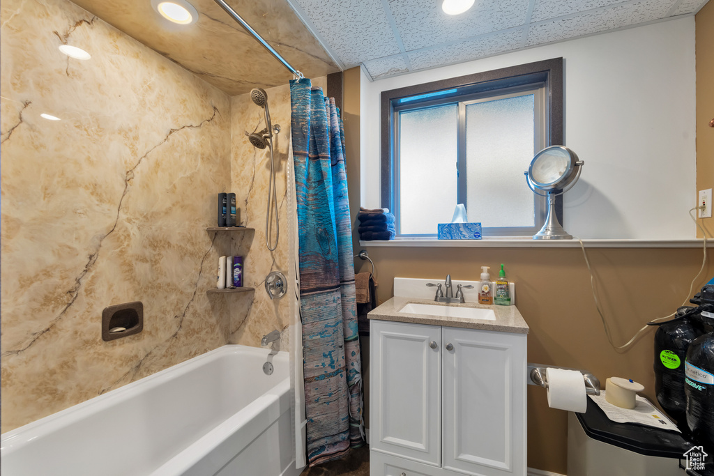 Bathroom featuring vanity, shower / bath combo, and a paneled ceiling