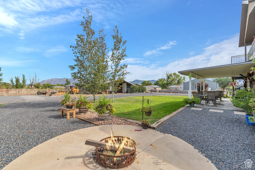 View of yard with a patio, a mountain view, and an outdoor fire pit