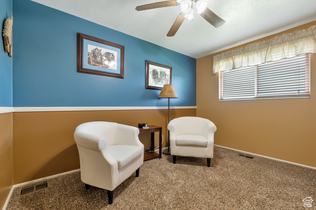 Sitting room featuring light carpet and ceiling fan