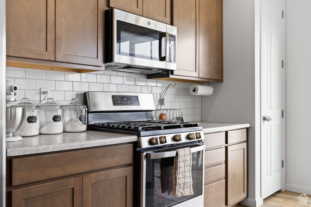 Kitchen featuring stainless steel appliances, tasteful backsplash, and light wood-type flooring