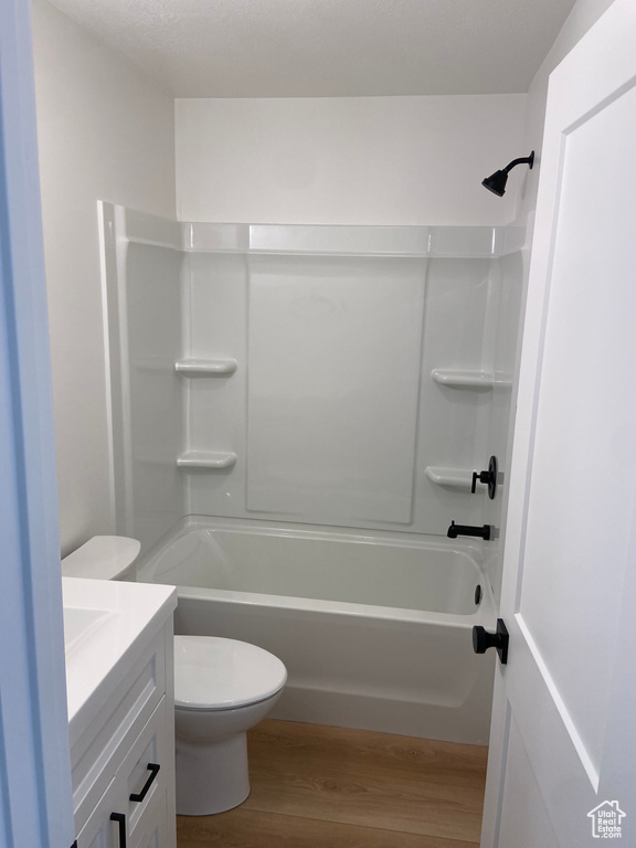 Full bathroom with vanity, toilet, hardwood / wood-style flooring, and bathtub / shower combination