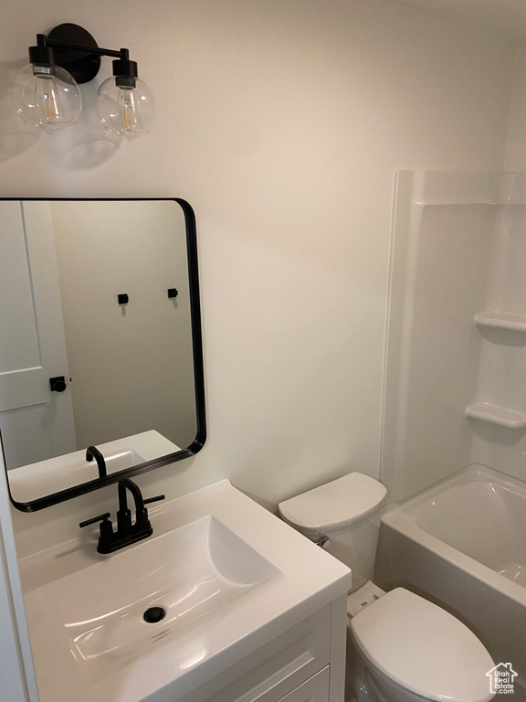 Full bathroom with vanity, shower / washtub combination, and toilet