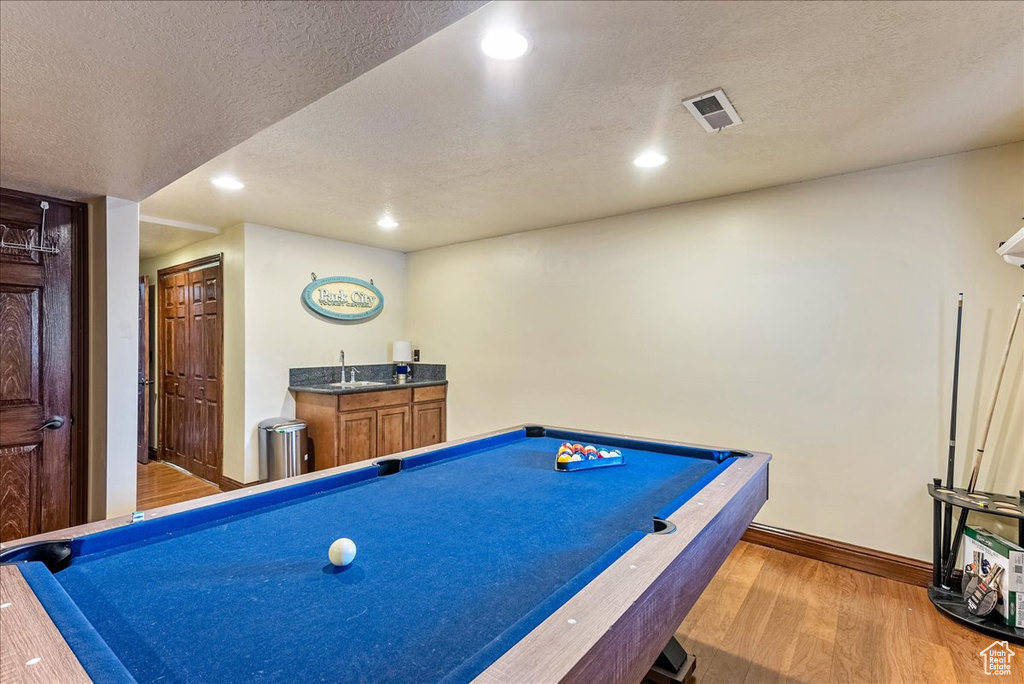Recreation room with light hardwood / wood-style flooring, a textured ceiling, and pool table