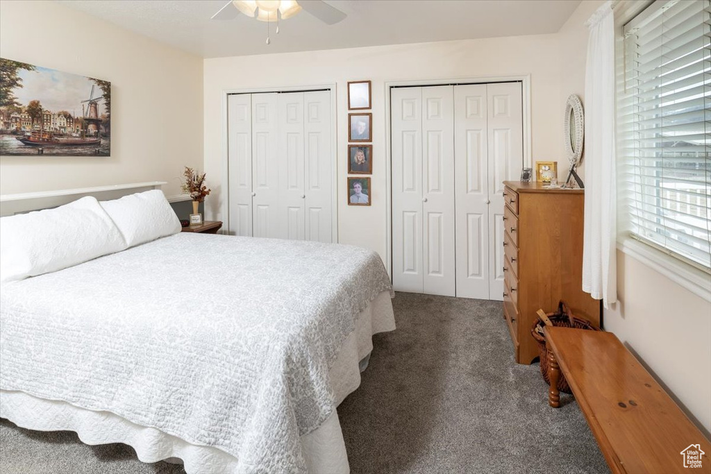 Bedroom with multiple closets, carpet floors, and ceiling fan