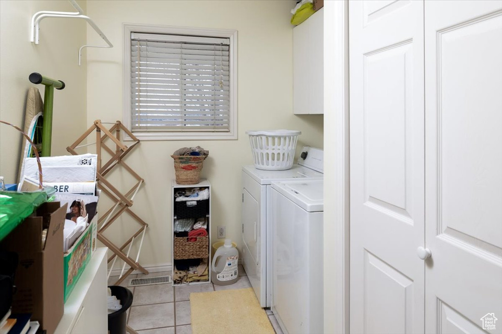 Washroom featuring light tile floors and washer and clothes dryer