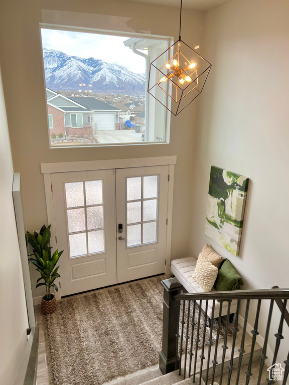 Entryway featuring a mountain view, french doors, carpet floors, and a chandelier