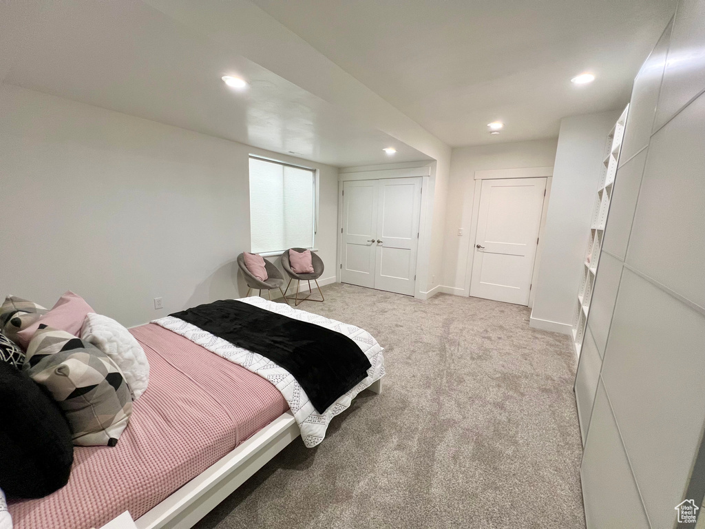 Bedroom featuring light carpet and a closet