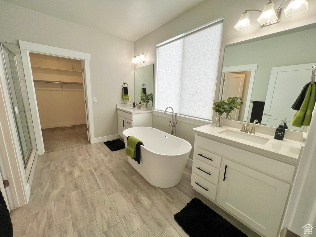 Bathroom with a tub, hardwood / wood-style floors, and vanity