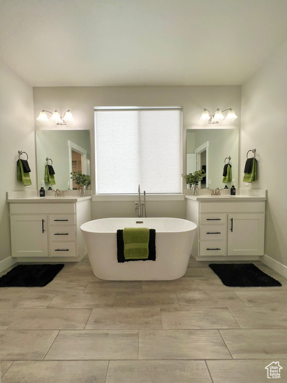 Bathroom with tile flooring, oversized vanity, and a washtub