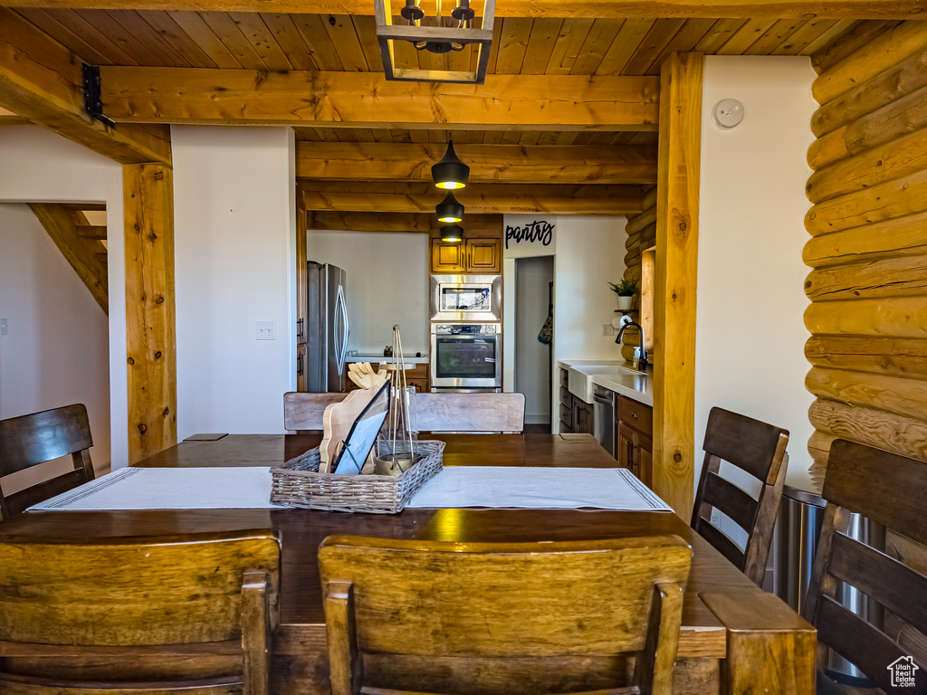 Dining room featuring log walls, wooden ceiling, and beam ceiling
