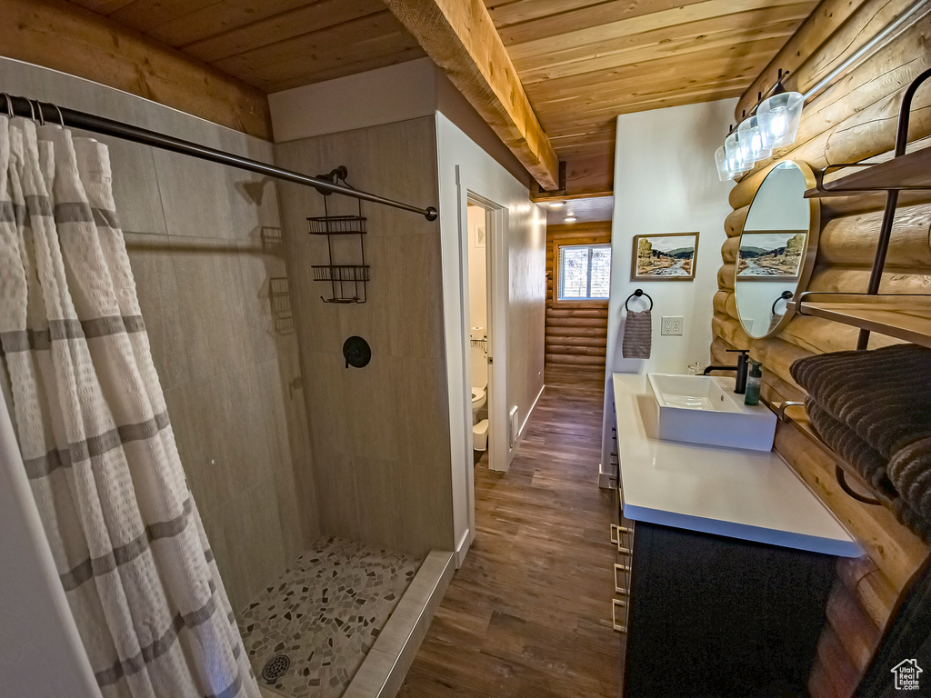 Bathroom with a shower with shower curtain, wooden ceiling, toilet, and vanity