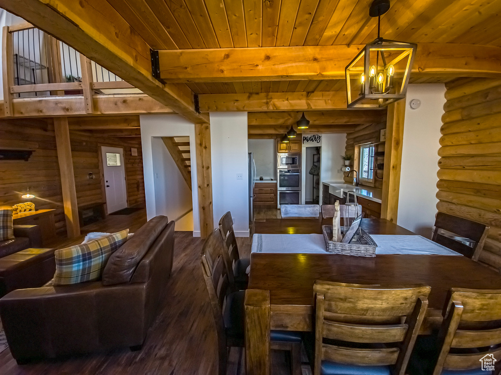 Dining area with log walls, dark hardwood / wood-style flooring, wood ceiling, and beamed ceiling