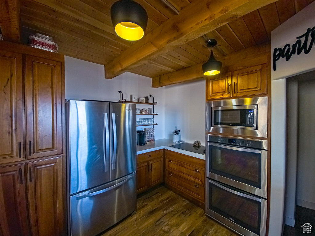 Kitchen featuring pendant lighting, stainless steel appliances, dark hardwood / wood-style flooring, and wooden ceiling