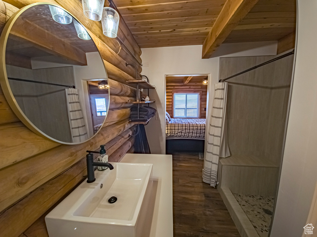 Bathroom featuring walk in shower, log walls, sink, wood ceiling, and wood-type flooring