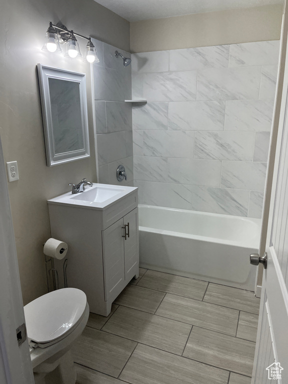 Full bathroom featuring vanity, toilet, and tiled shower / bath combo