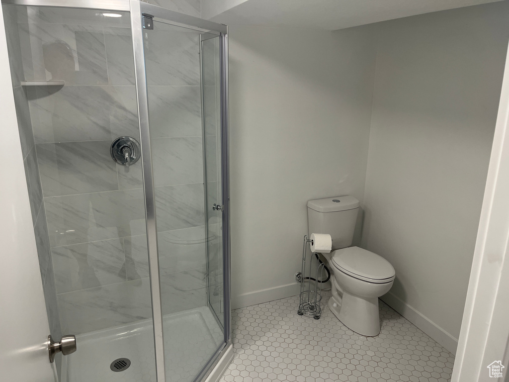 Bathroom with toilet, tile flooring, and walk in shower