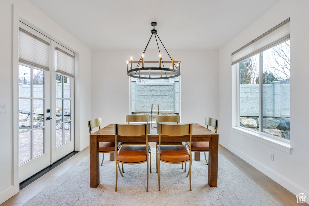 Dining room featuring a notable chandelier, french doors, and light hardwood / wood-style floors