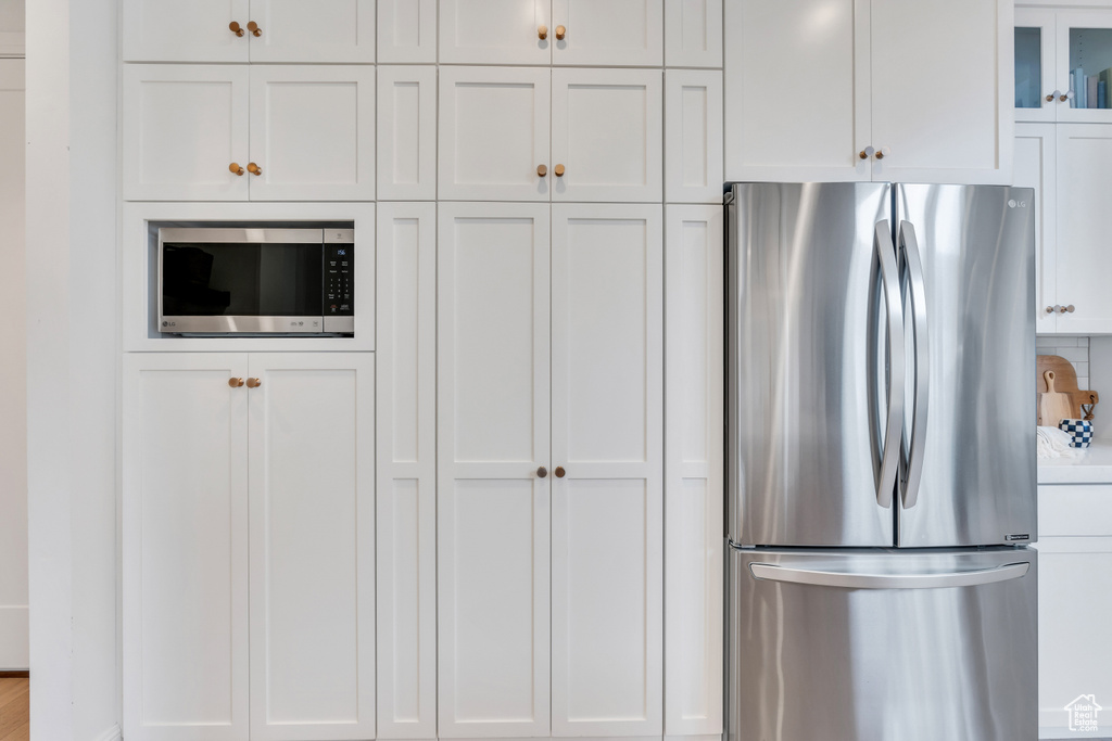 Kitchen featuring appliances with stainless steel finishes and white cabinetry