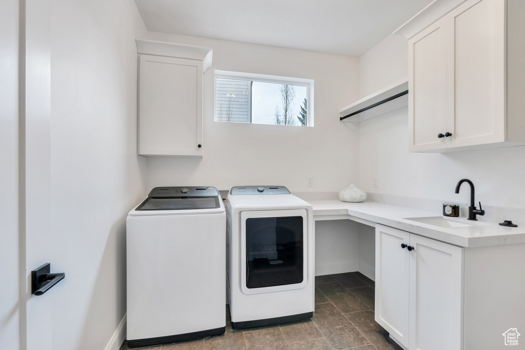 Laundry room featuring washer and dryer, sink, cabinets, and tile floors