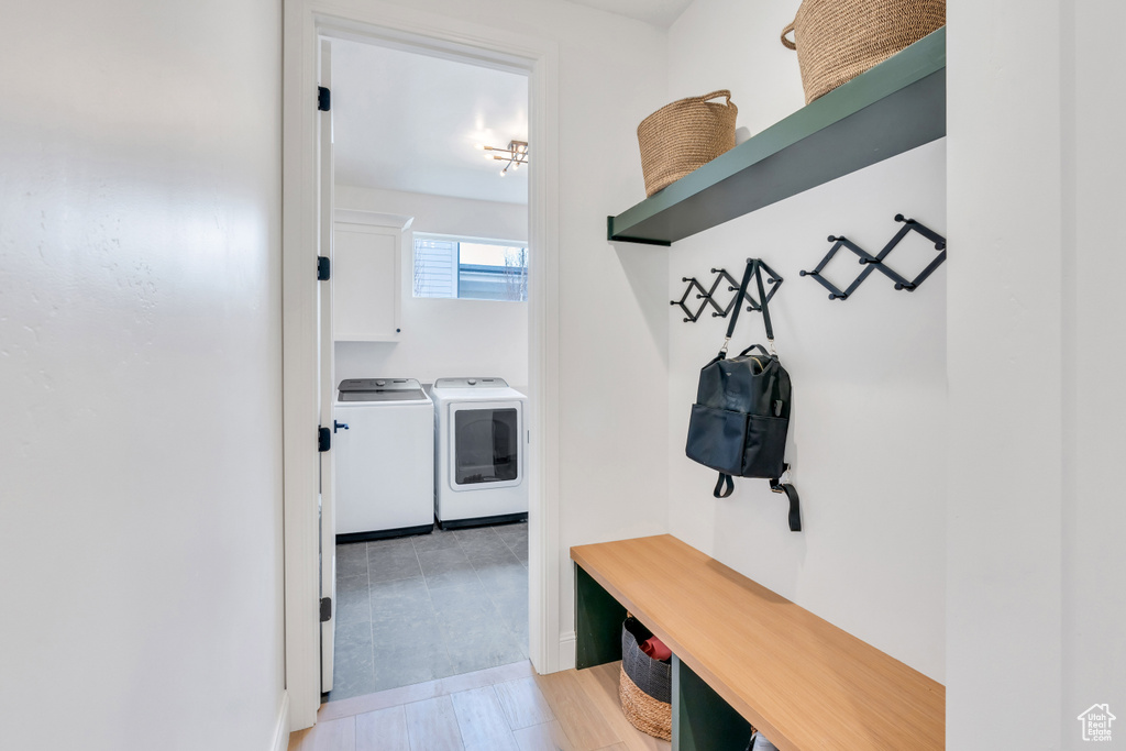 Mudroom featuring washing machine and dryer and light tile floors