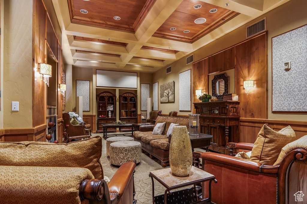 Carpeted home theater with coffered ceiling, ornamental molding, beam ceiling, and wooden walls