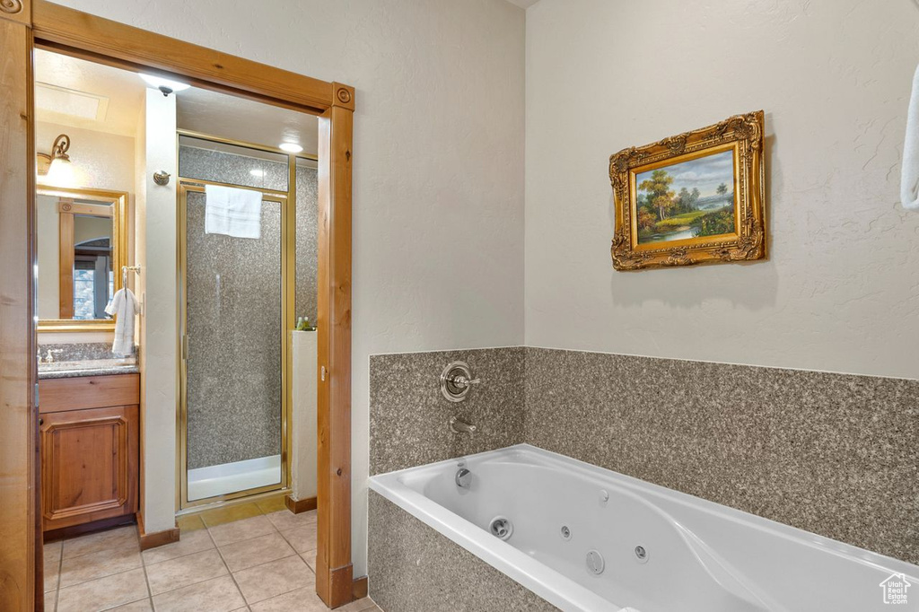 Bathroom featuring vanity, tile floors, and plus walk in shower
