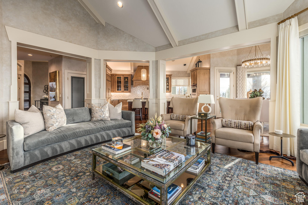 Living room with beam ceiling, high vaulted ceiling, and hardwood / wood-style flooring