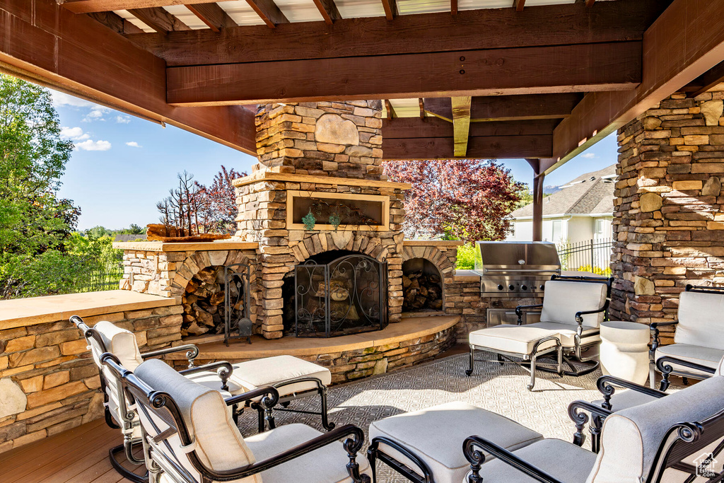 View of patio / terrace featuring an outdoor stone fireplace and a grill