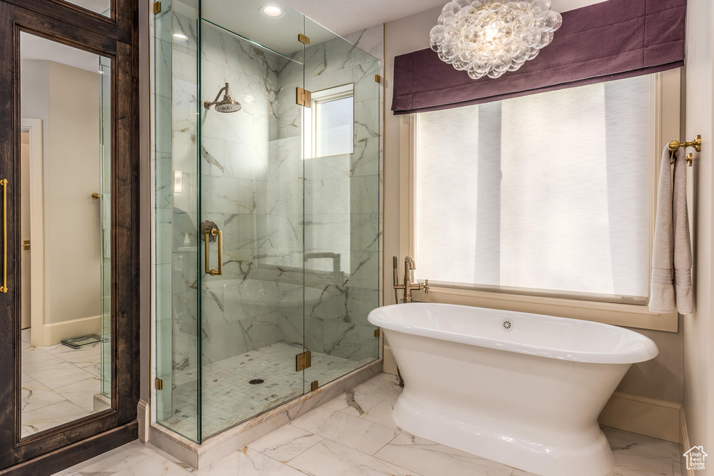 Bathroom featuring tile flooring, an inviting chandelier, and separate shower and tub