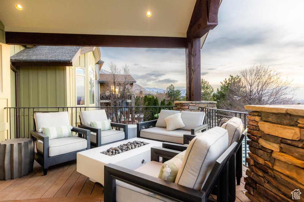 Balcony at dusk featuring an outdoor living space with a fire pit