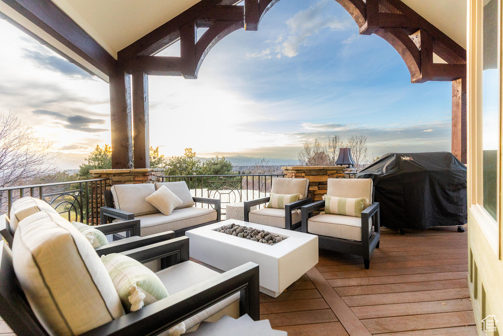 Deck at dusk with a grill and an outdoor living space with a fire pit