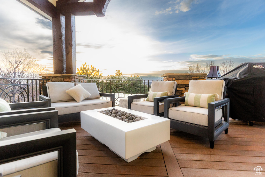 Deck at dusk featuring an outdoor living space with a fire pit