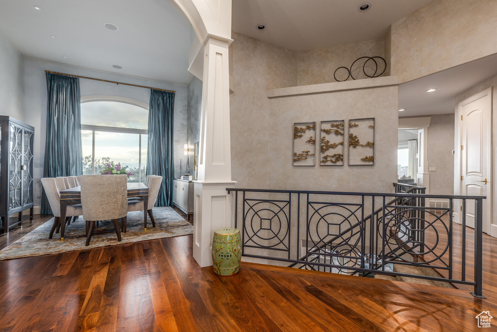 Hallway with dark wood-type flooring and decorative columns