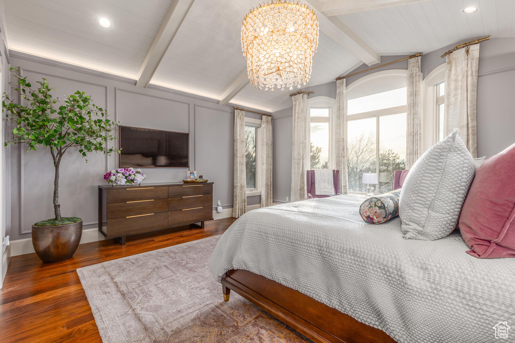 Bedroom with a notable chandelier, dark hardwood / wood-style floors, and lofted ceiling with beams