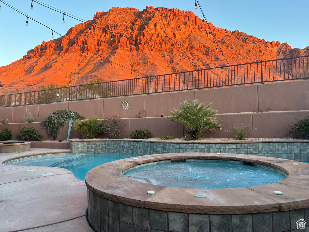 View of swimming pool featuring a mountain view and an in ground hot tub