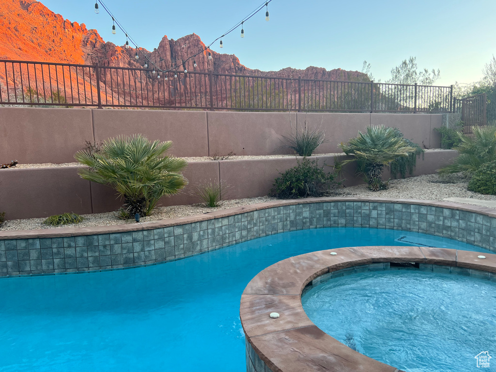 View of pool featuring a mountain view and an in ground hot tub