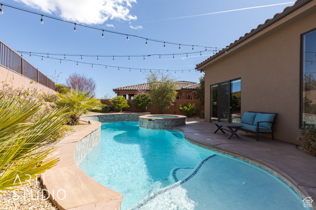 View of pool with a patio area and an in ground hot tub