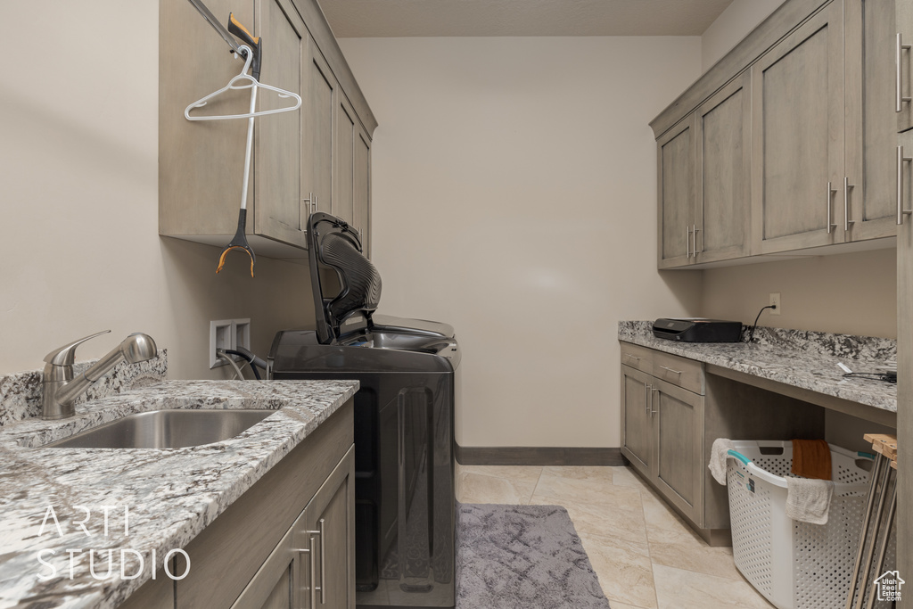 Laundry room with sink, cabinets, washer / clothes dryer, and light tile floors