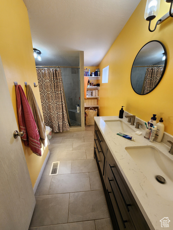 Bathroom with tile flooring, toilet, double sink, and oversized vanity