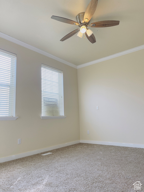 Spare room with light colored carpet, ornamental molding, and ceiling fan