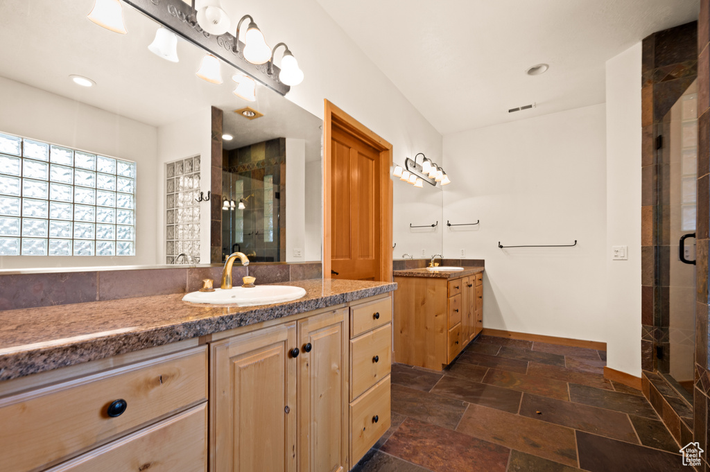 Bathroom with an enclosed shower, tile flooring, and double sink vanity