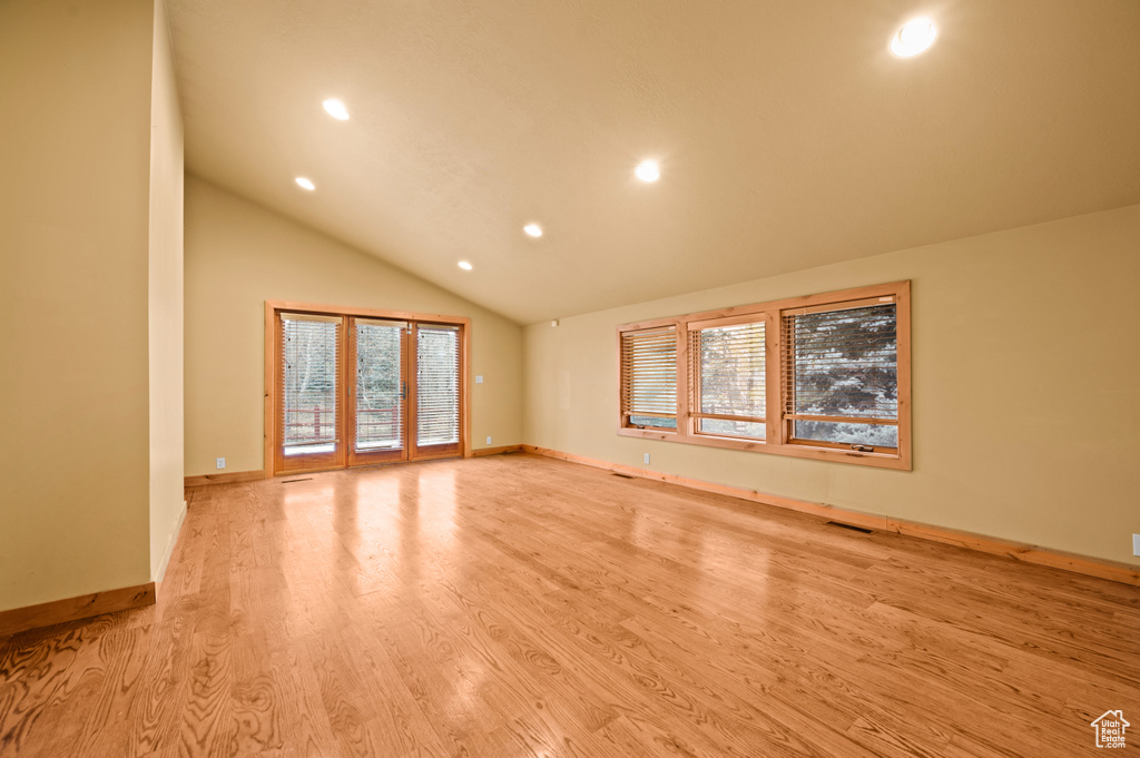 Unfurnished room with vaulted ceiling and light hardwood / wood-style floors