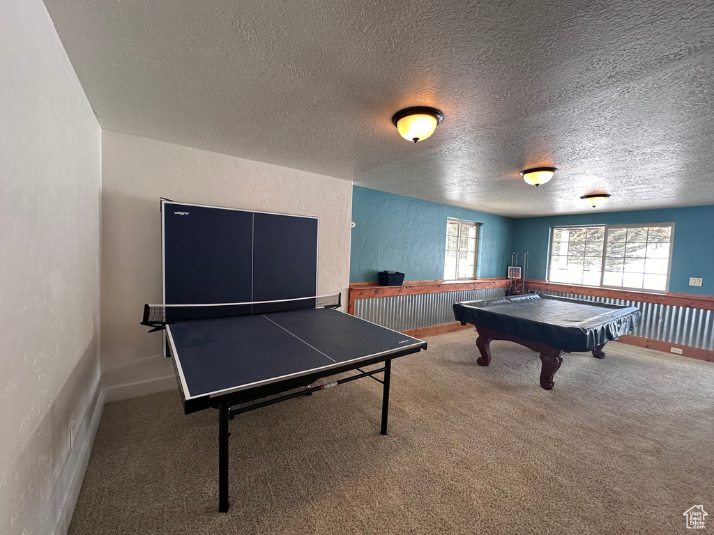 Playroom with carpet floors, a textured ceiling, and billiards