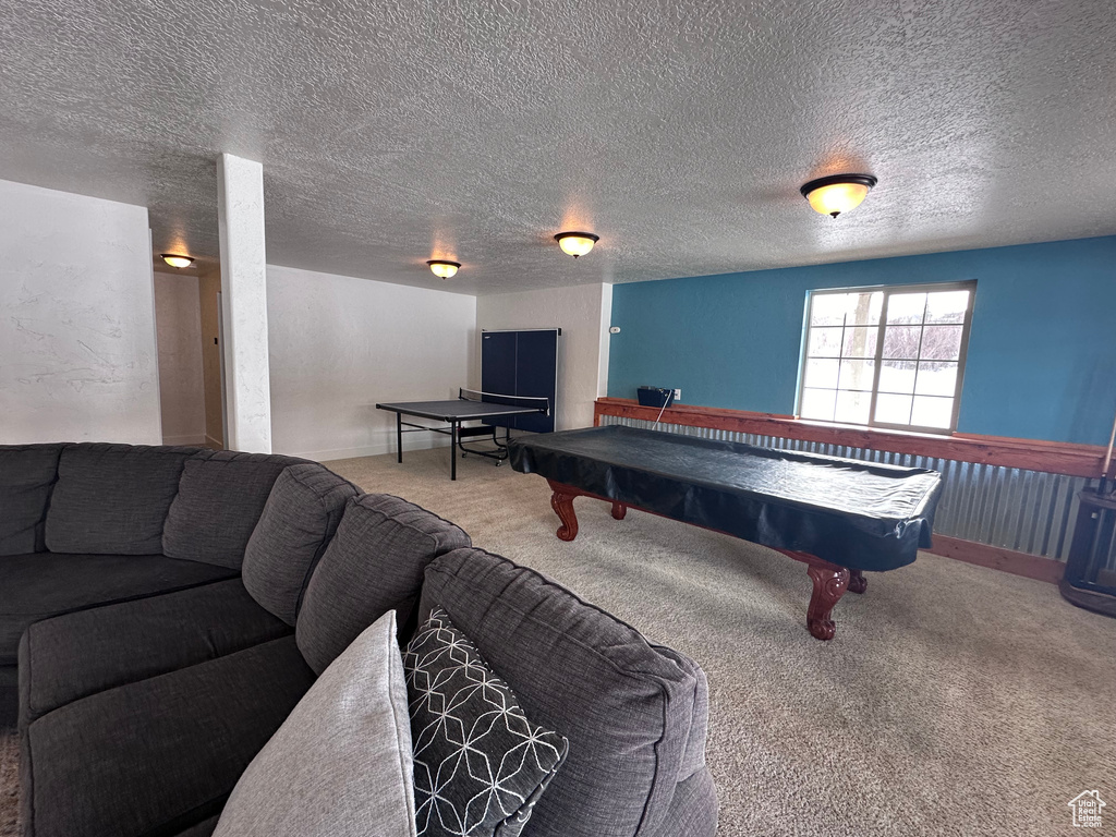 Recreation room with light colored carpet, a textured ceiling, and pool table