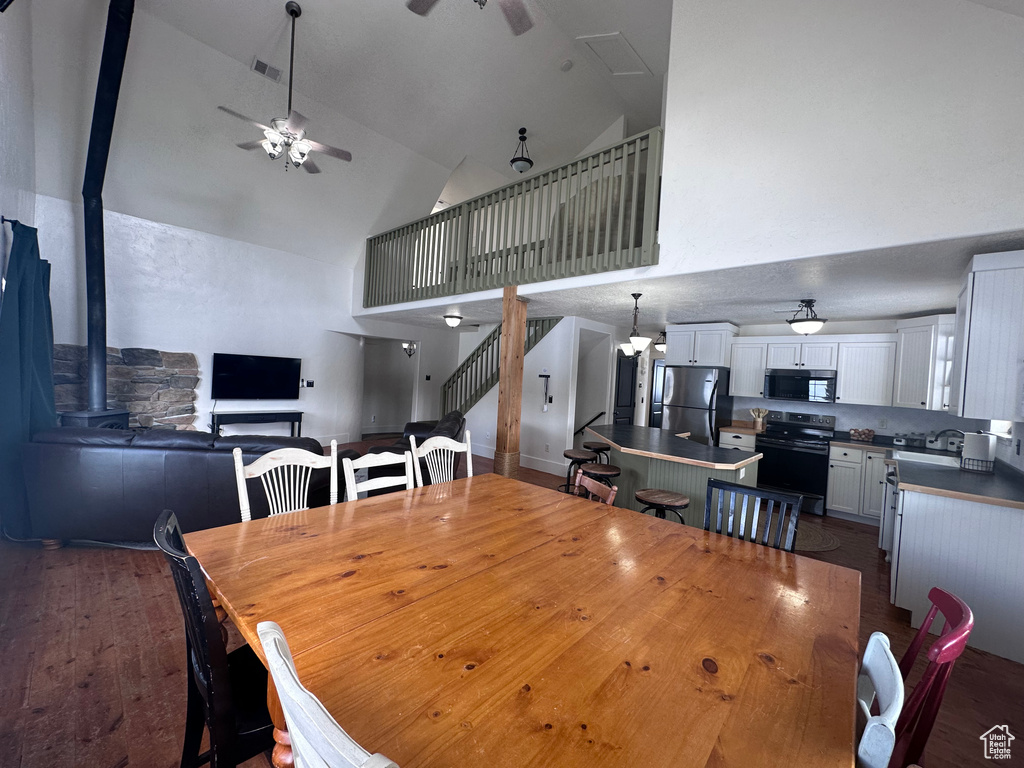 Dining area featuring ceiling fan and high vaulted ceiling