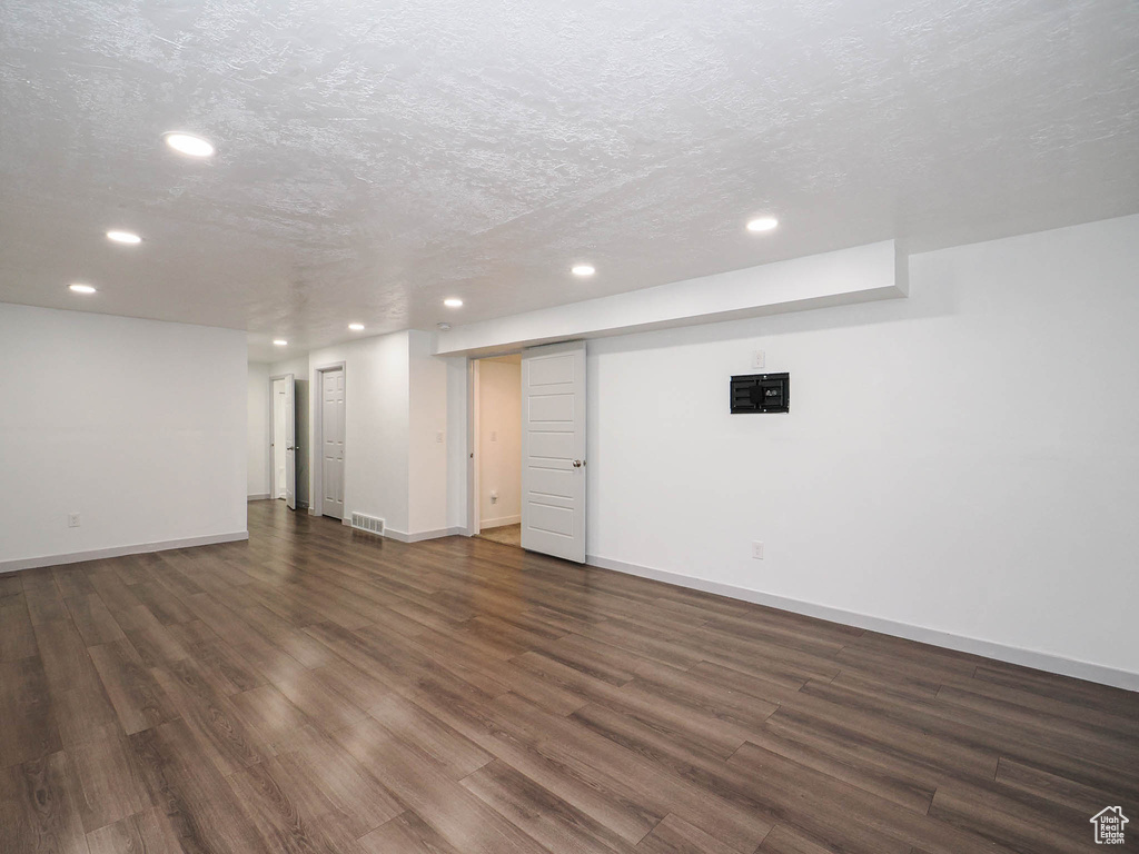 Basement featuring dark hardwood / wood-style flooring and a textured ceiling