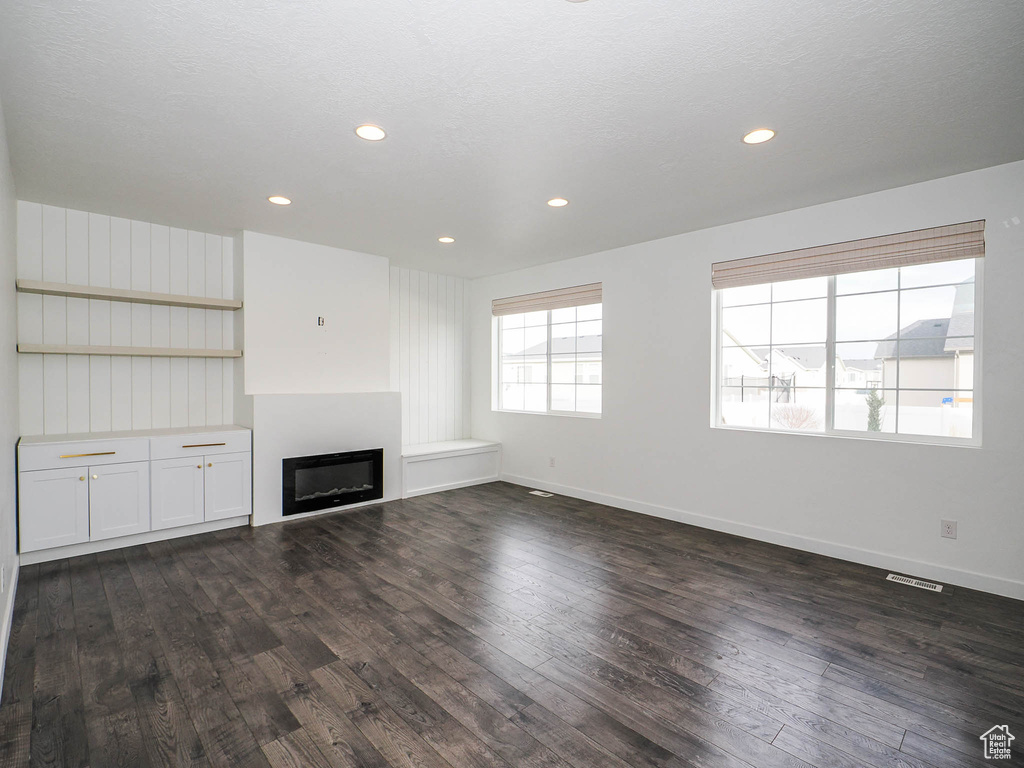 Unfurnished living room featuring dark hardwood / wood-style floors