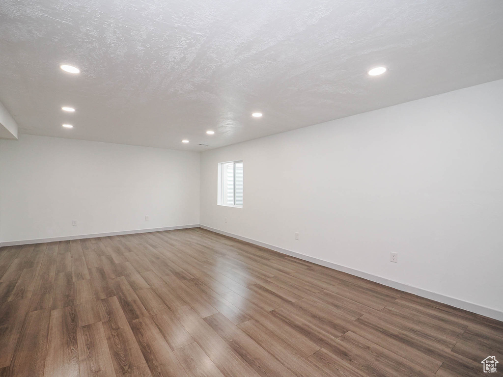 Empty room featuring dark hardwood / wood-style flooring and a textured ceiling