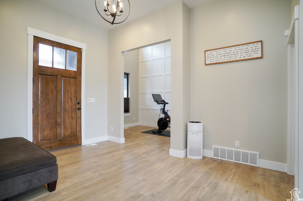 Entrance foyer featuring a notable chandelier, light hardwood / wood-style flooring, and a wealth of natural light
