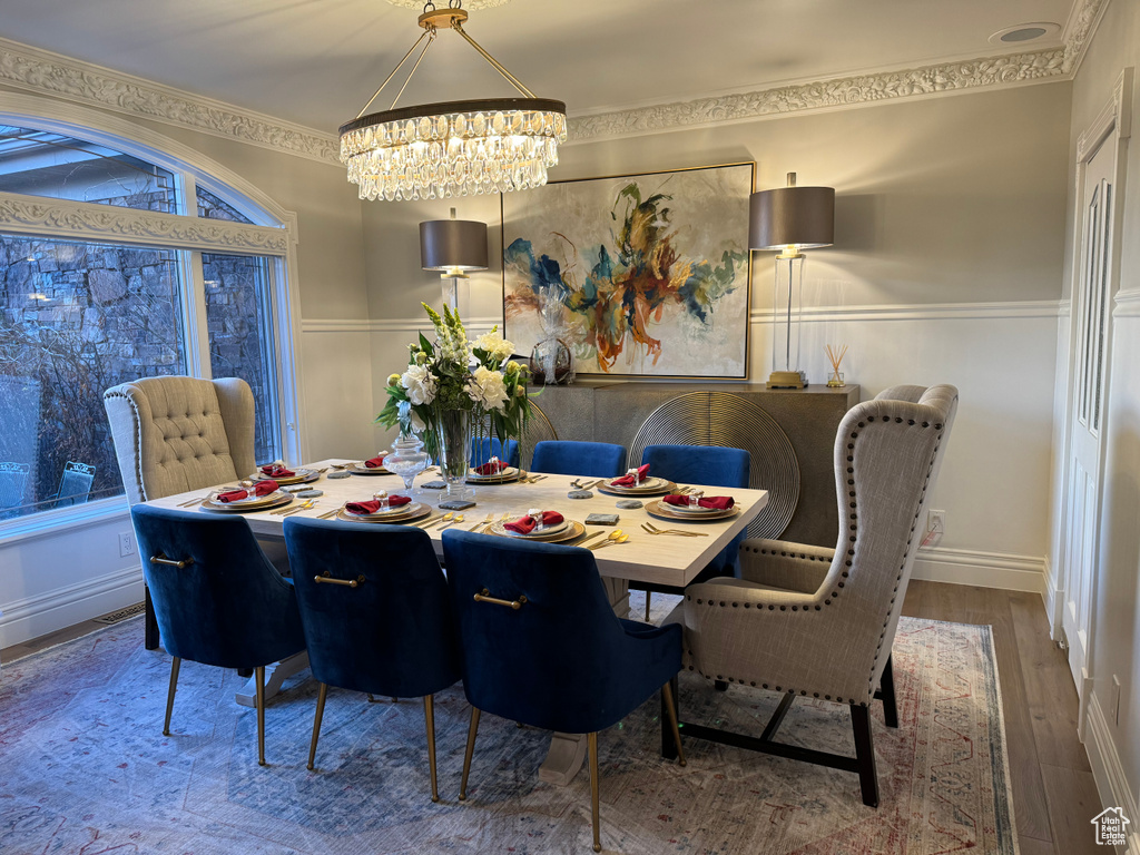 Dining space featuring a chandelier, dark hardwood / wood-style flooring, and crown molding